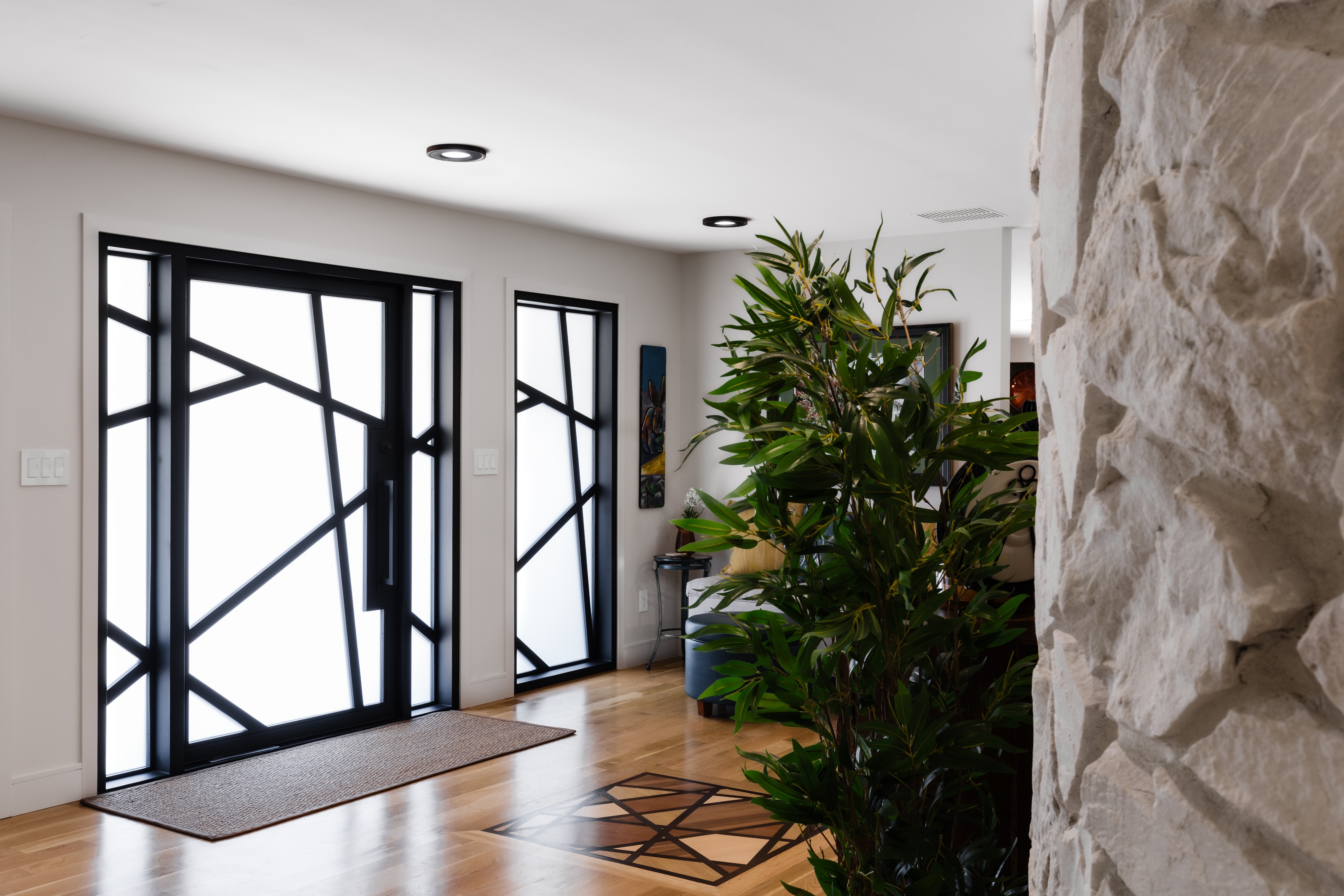 Entryway with Dramatic Geometric Black Window Frames and Stone Wall